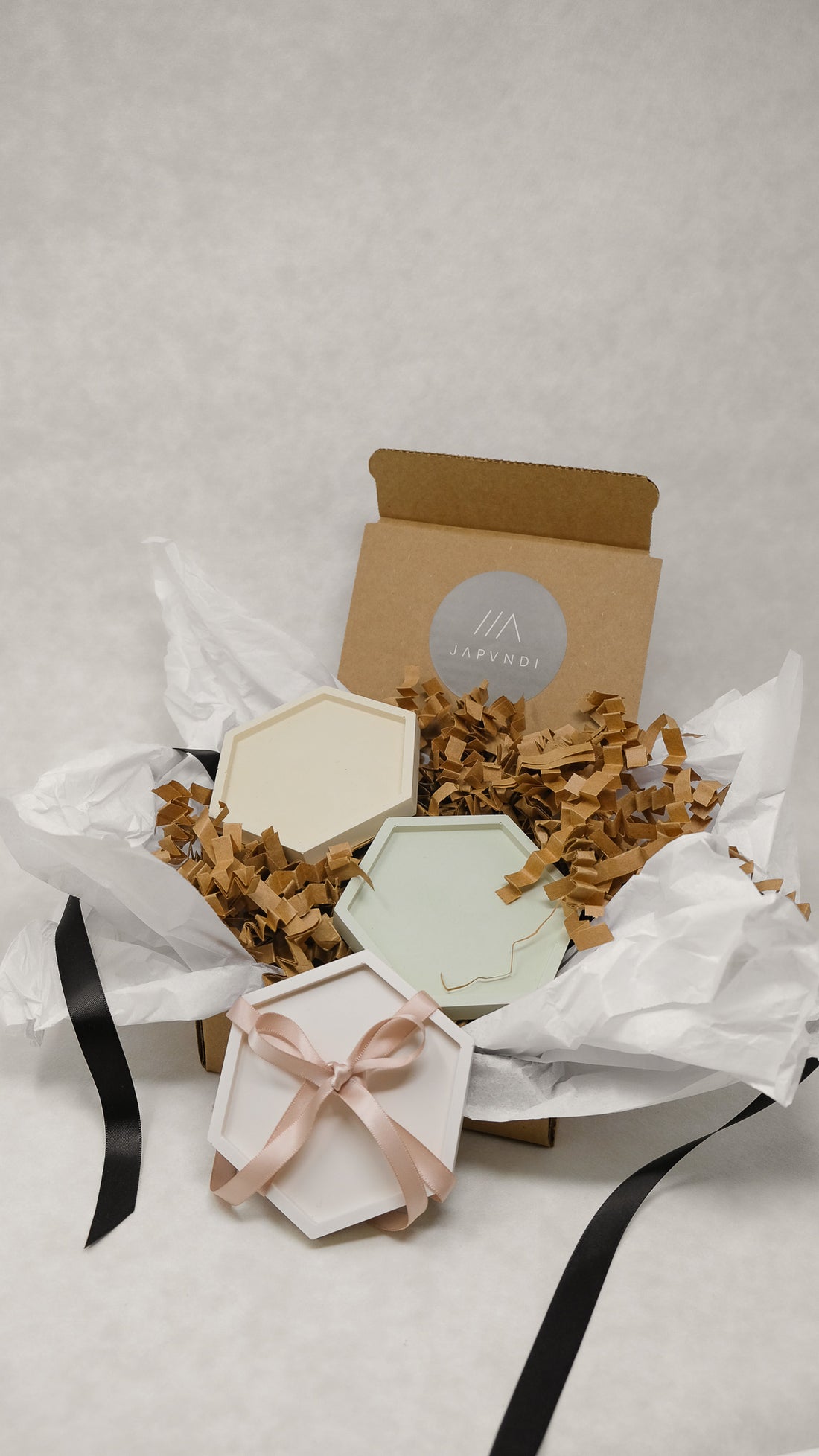 jesmonite coaster in cream beige and sage with gift wrapping in scandinanvian style